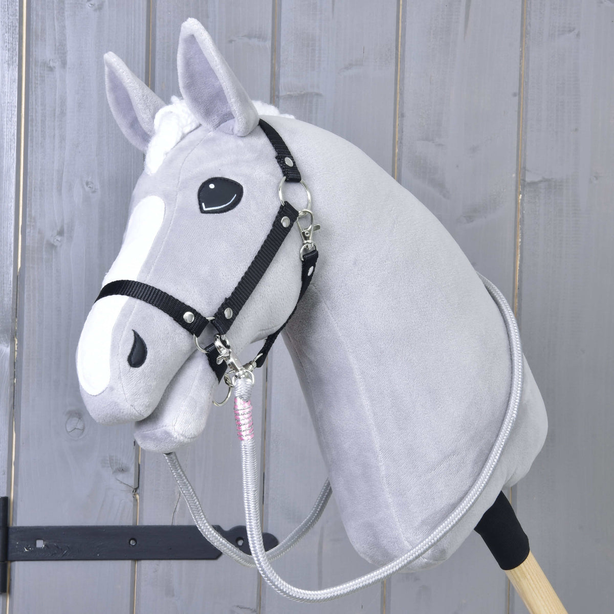 Lichtgrijze Hobby Horse met zwart halster en grijze Teugels Tizian met roze omwikkelingen onder de kin