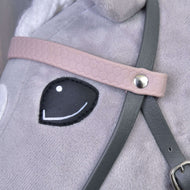 Close-up of the pale pink textured headband with a silver rivet on the grey leatherette bridle beside the Hobby Horse eye
