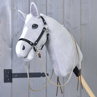 Grijze Hobby Horse met zwart halster en de beige open westernteugels vastgeklikt, bruine leren uiteinden langs de hals