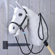 Grijze Hobby Horse met zwart halster en de zwarte westernteugels aan beide kanten vastgeklikt en over de hals gelegd