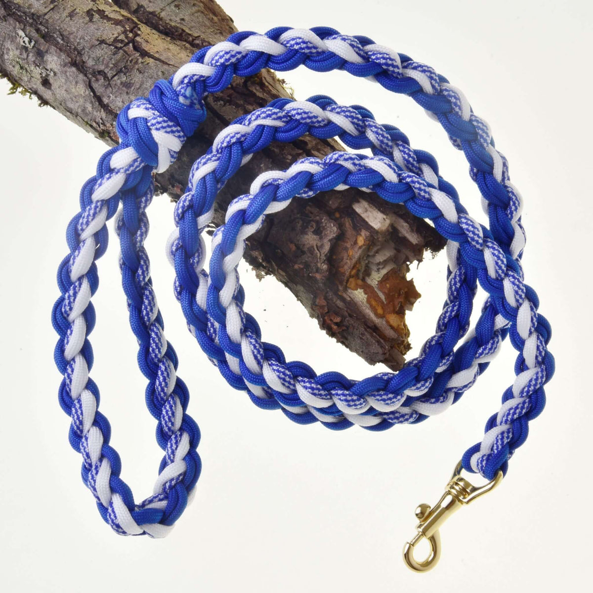 Longe tressée bleu et blanc pour Hobby Horse avec mousqueton couleur laiton, posée sur une branche