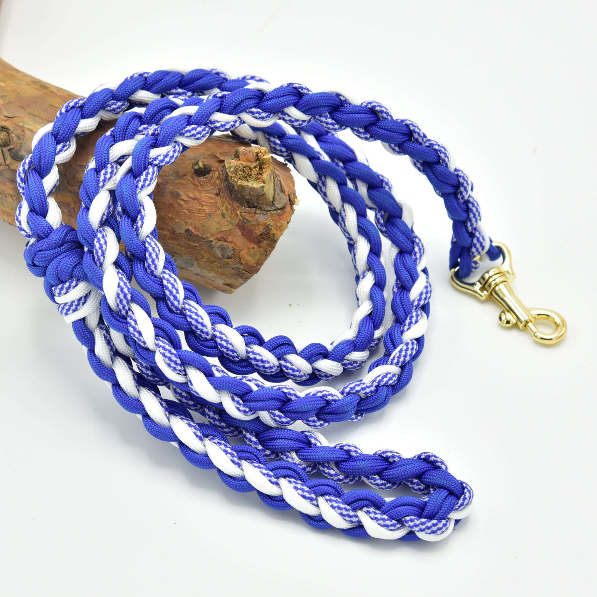 Hobby Horse longe tressée blanc/bleu LarDen en cordon bleu roi et blanc avec mousqueton doré, sur une bûche