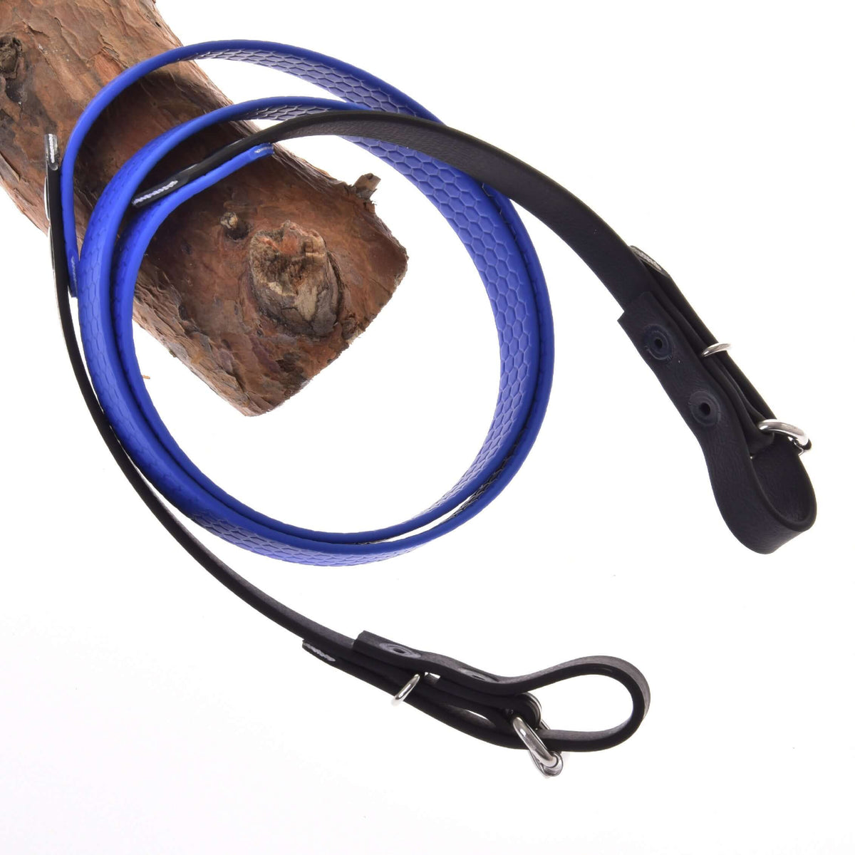 Gerubberde teugels blauw van LarDen voor Hobby Horse met grijpvaste honingraatstructuur en zwarte uiteinden met gespen over een tak