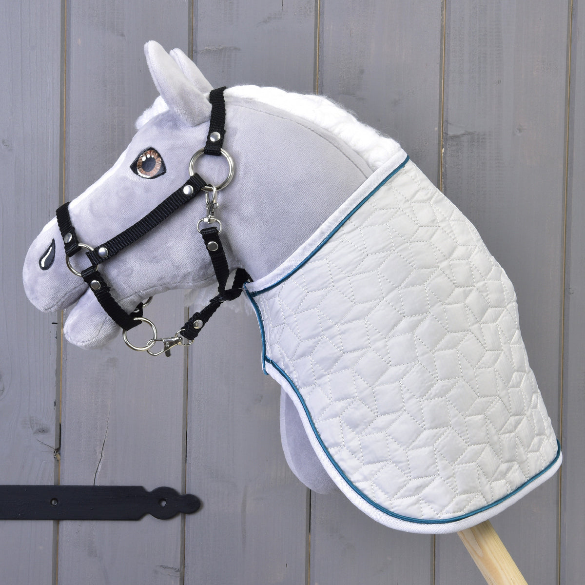 Grey Hobby Horse with a white mane and black halter in left profile, wearing the white quilted Thermo Pearl blanket